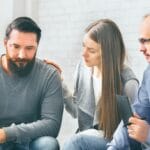 Group supporting depressed man with alcoholism problem