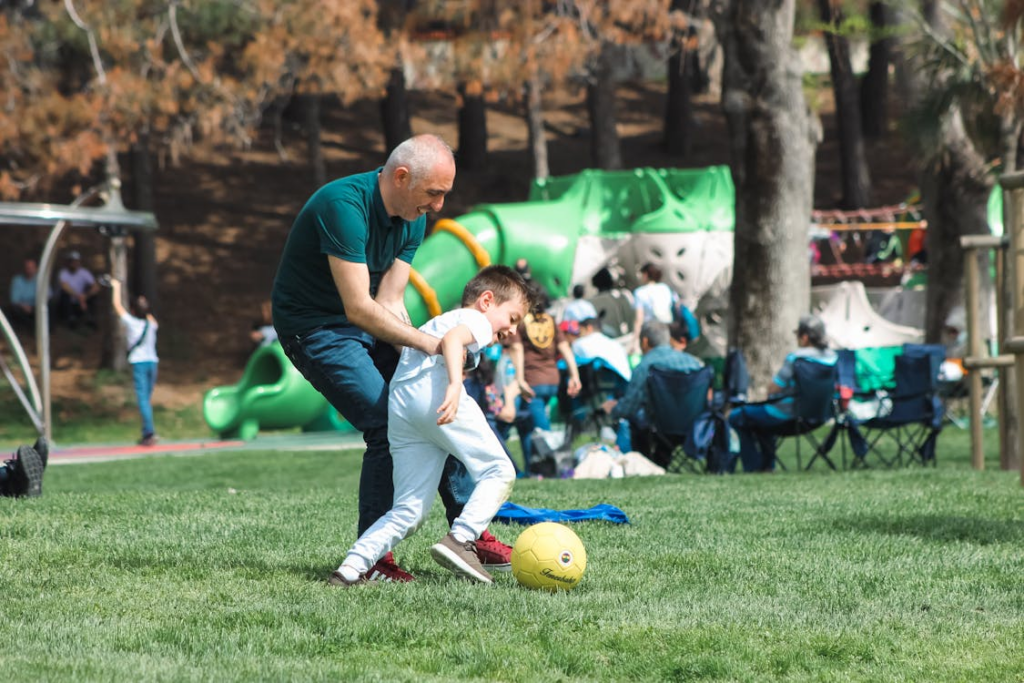 a person playing ball with their son