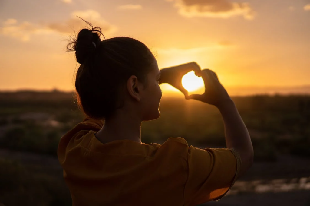 a woman doing a hand heart sign