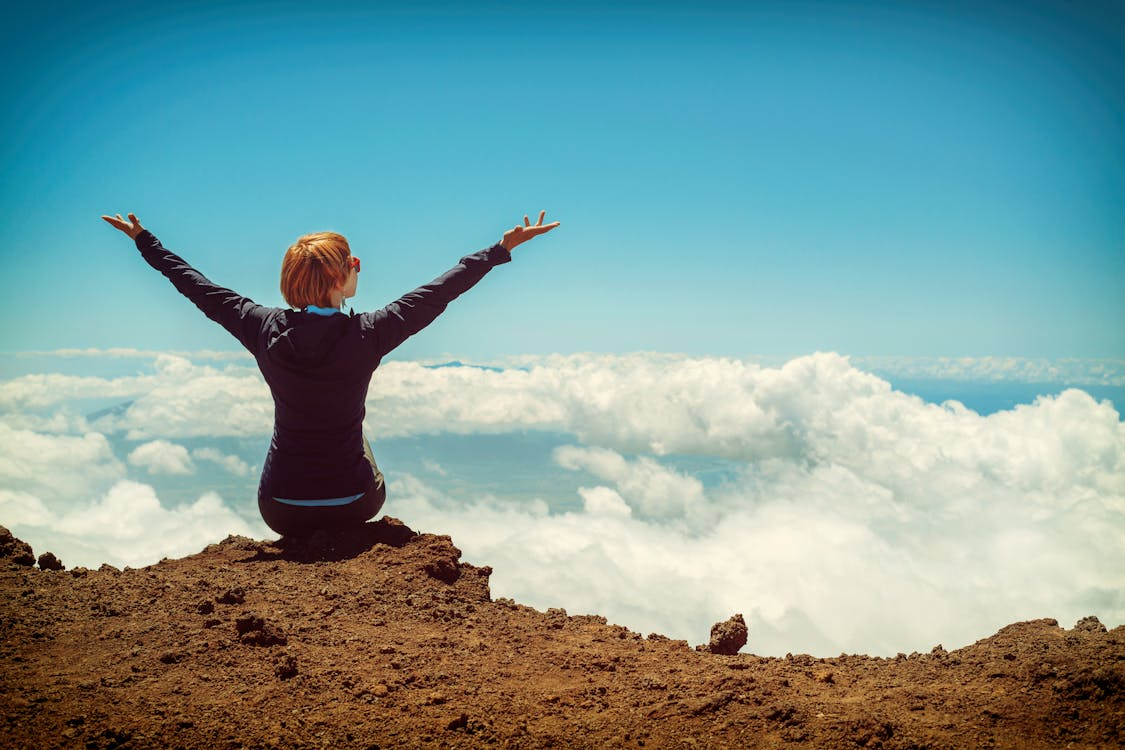 a person sitting on a cliff