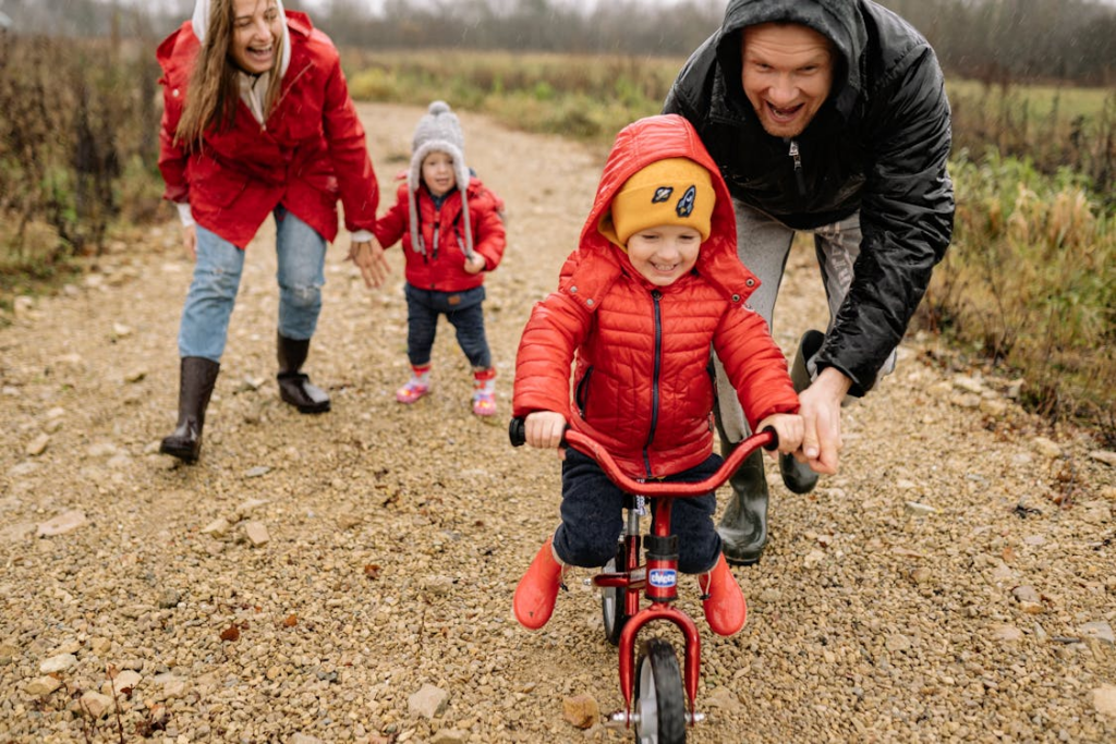 a family teaching kids to ride bikes