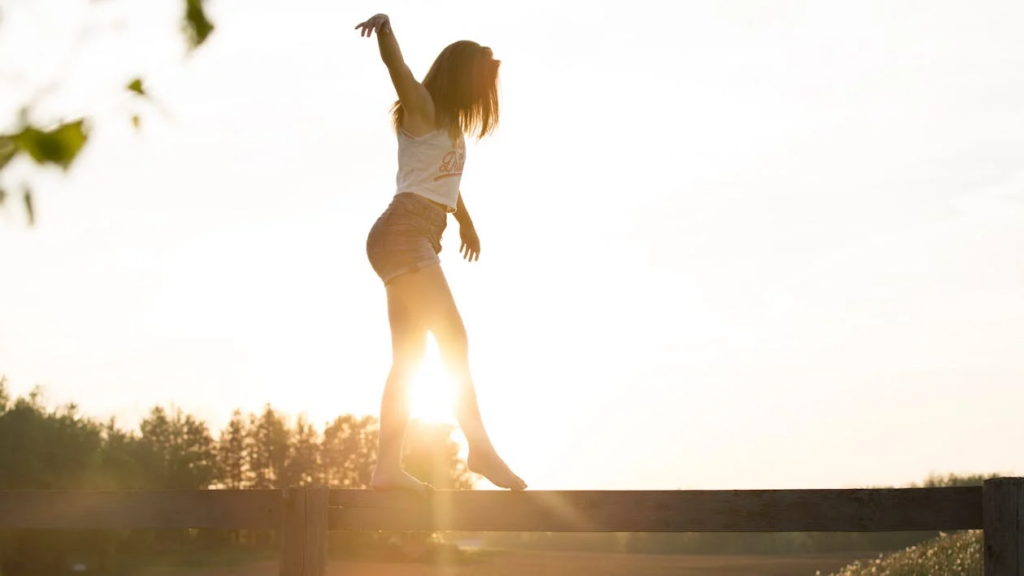  a woman walking on a fence