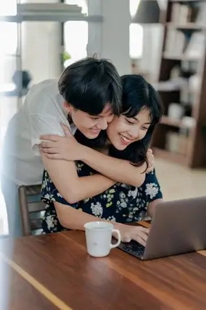 a person hugging another from behind
