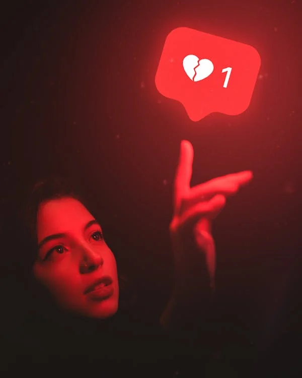 A person reaching out to touch a ‘dislike’ sign