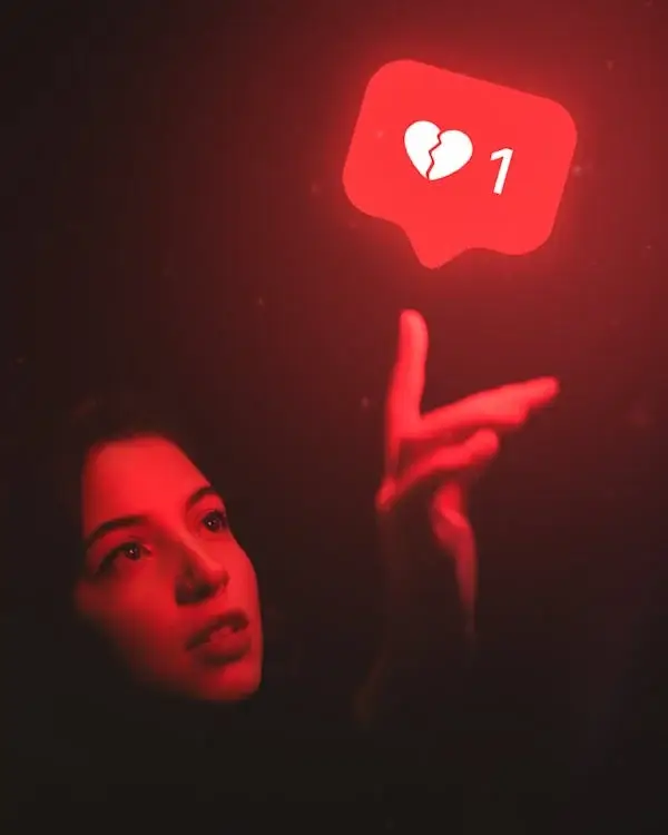 A person reaching out to touch a ‘dislike’ sign